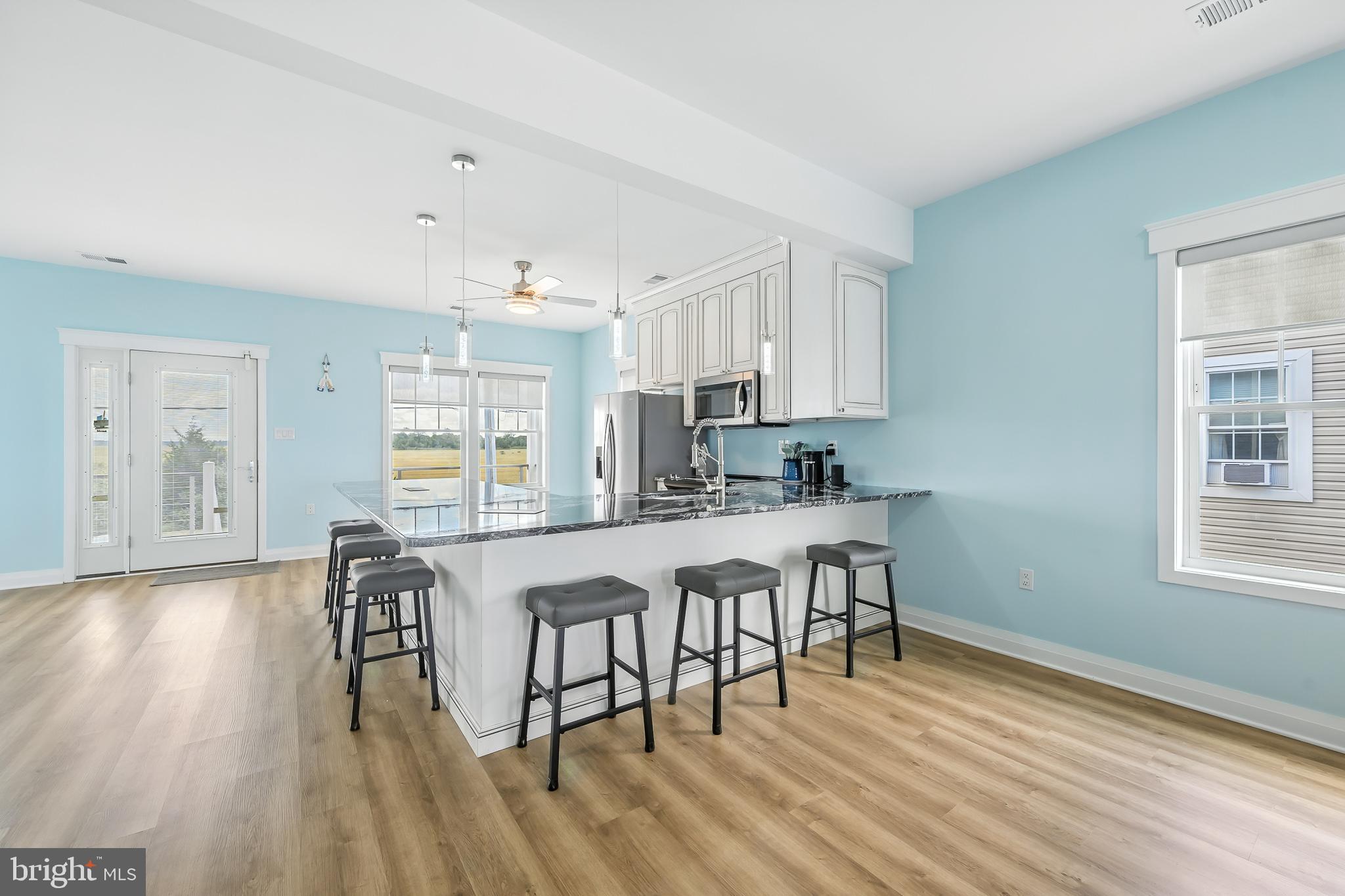 549 Bay Avenue Milford, DE 19963 - Photo 10 of 60 a kitchen with stainless steel appliances granite countertop a stove top oven a sink dishwasher and white cabinets with wooden floor