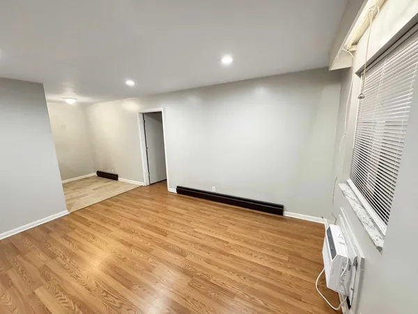 a view of an empty room with wooden floor