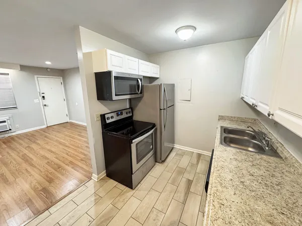 a kitchen with granite countertop a stove and a microwave