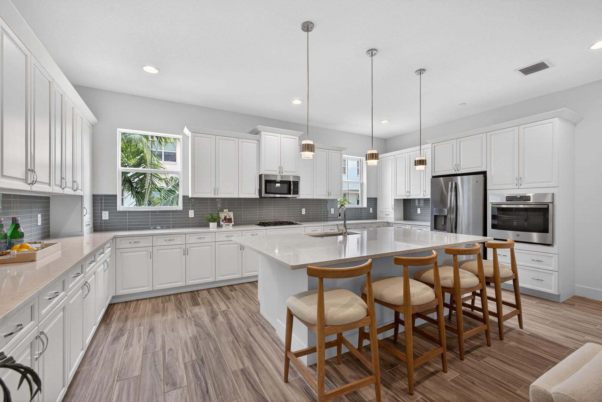 13392 Alton Road Palm Beach Gardens, FL 33418 - Photo 19 of 57 a kitchen with white cabinets and stainless steel appliances