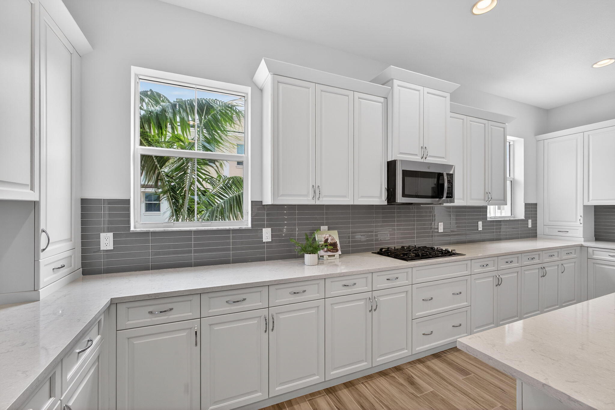 13392 Alton Road Palm Beach Gardens, FL 33418 - Photo 23 of 57 a kitchen with white cabinets a window and a sink