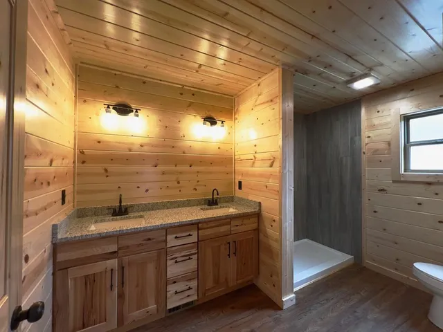 a bathroom with a granite countertop sink mirror and shower