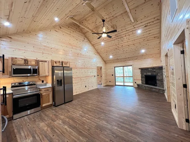 a view of a kitchen with a stove wooden cabinets and a fireplace
