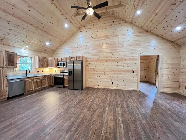 a kitchen with stainless steel appliances wooden floors and view living room