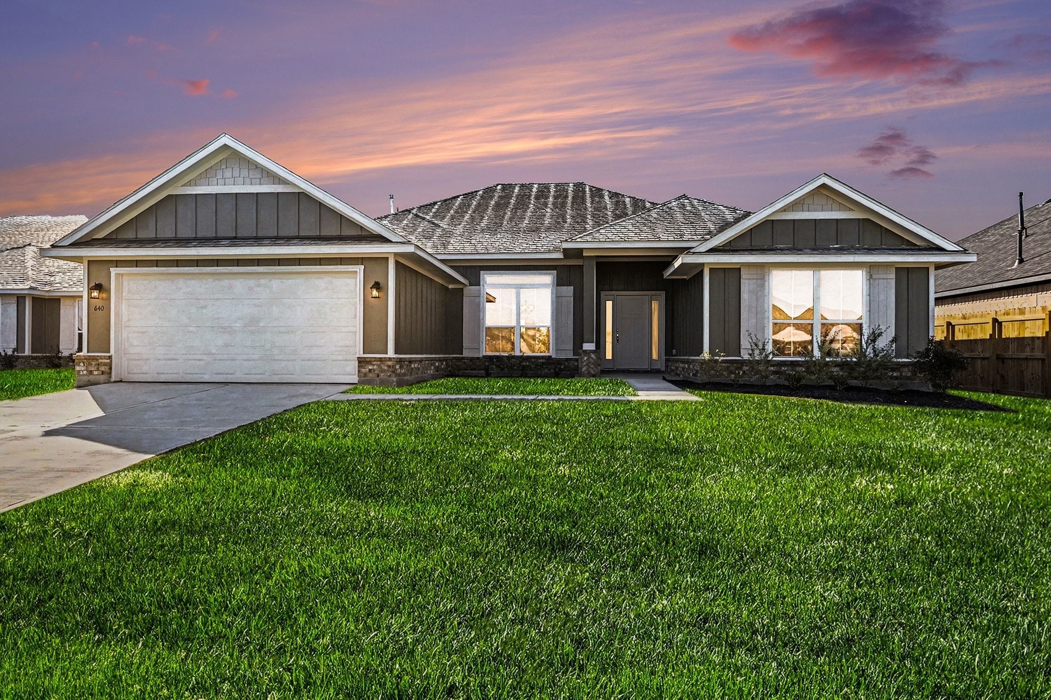 a front view of a house with a yard and potted plants