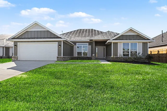 a front view of a house with a yard and trees
