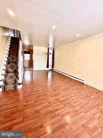 a view of an empty room with wooden floor