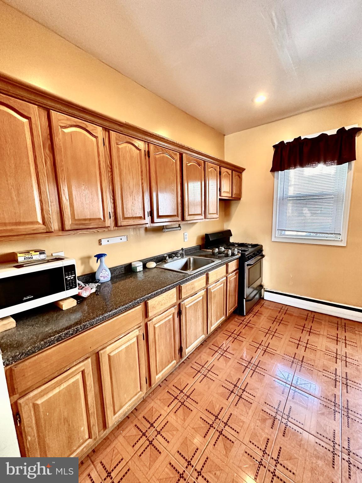 3223 North Bambrey Street Philadelphia, PA 19129 - Photo 6 of 14 a kitchen with stainless steel appliances granite countertop a stove a sink and a microwave