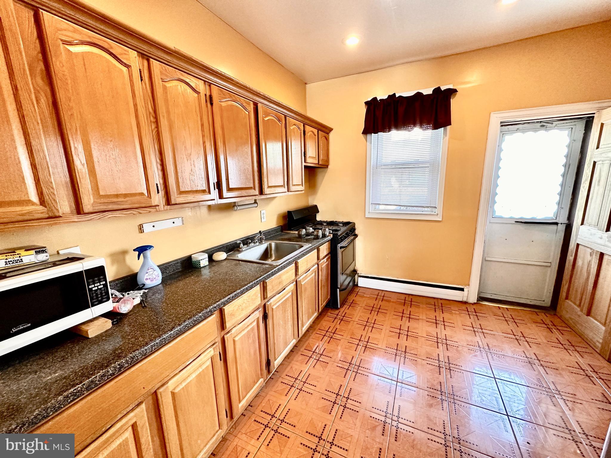 3223 North Bambrey Street Philadelphia, PA 19129 - Photo 7 of 14 a kitchen with stainless steel appliances a stove a sink and a refrigerator