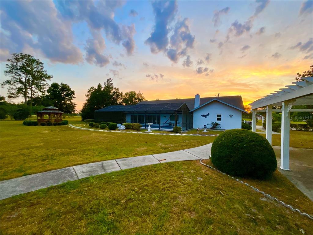 7205 Northeast 61st Ave Road Silver Springs, FL 34488 - Photo 40 of 64 a front view of a house with a yard