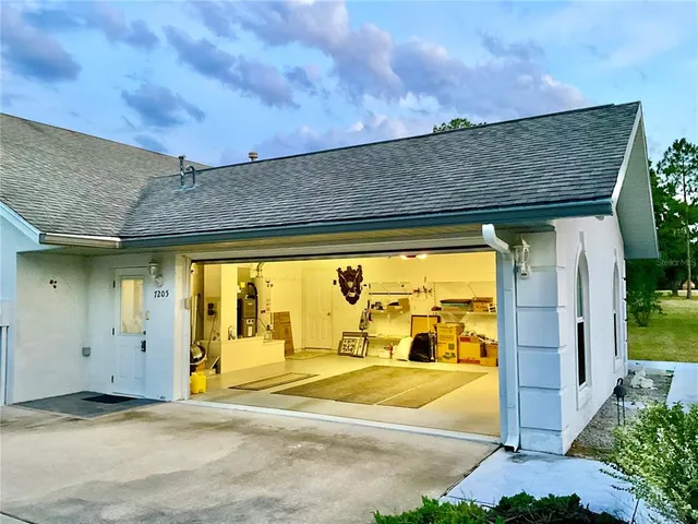 a view of a house with a big yard and large trees