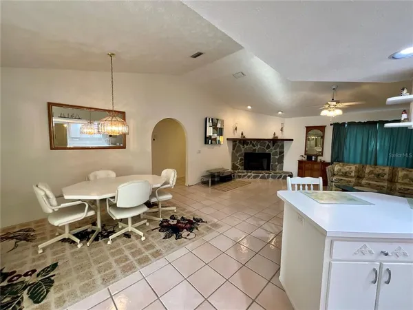 a living room with furniture a dining table and kitchen view