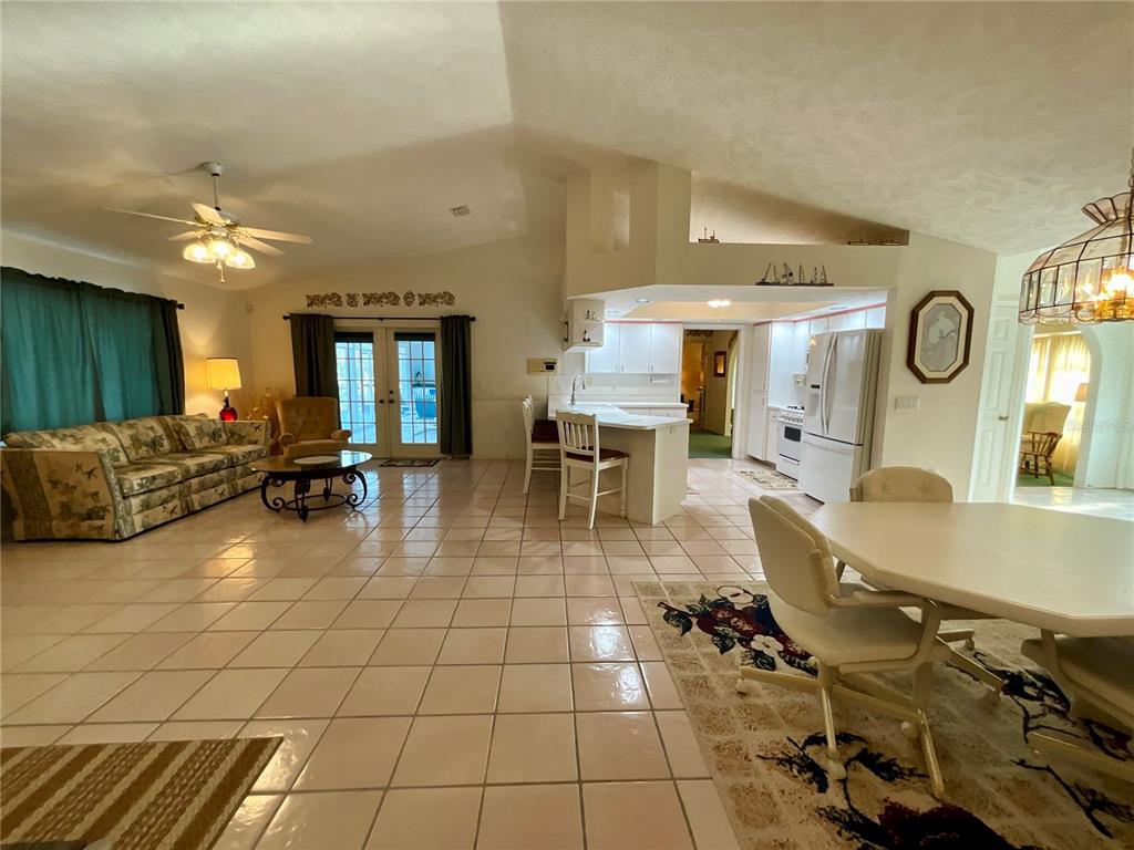7205 Northeast 61st Ave Road Silver Springs, FL 34488 - Photo 9 of 64 a living room with couches a dining table and with potted plants with wooden floor