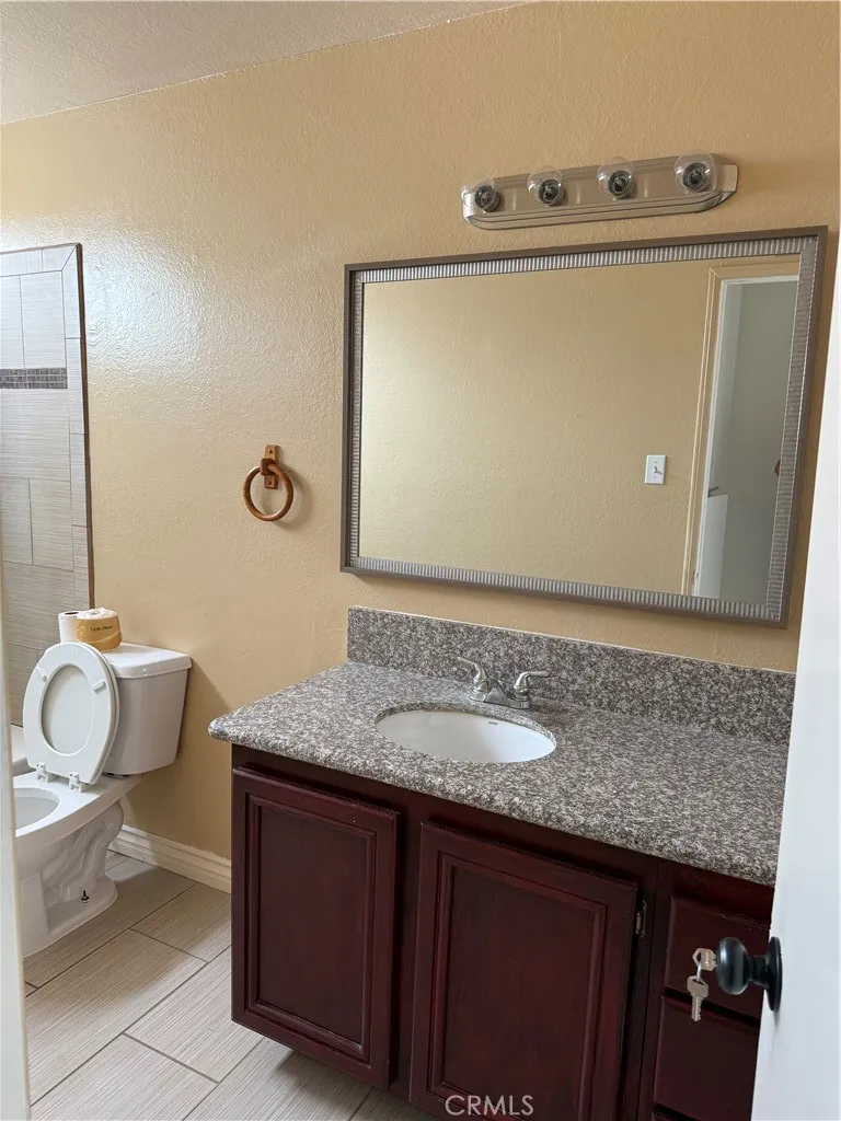 3791 Harvill Lane, Unit 4 Riverside, CA 92503 - Photo 5 of 10 a bathroom with a granite countertop sink and a mirror