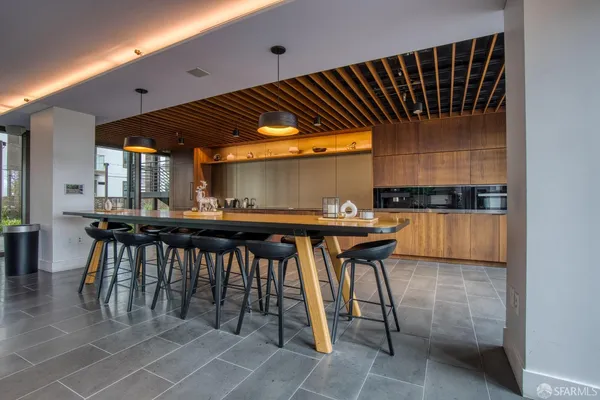 a kitchen with stainless steel appliances kitchen island granite countertop a table and chairs