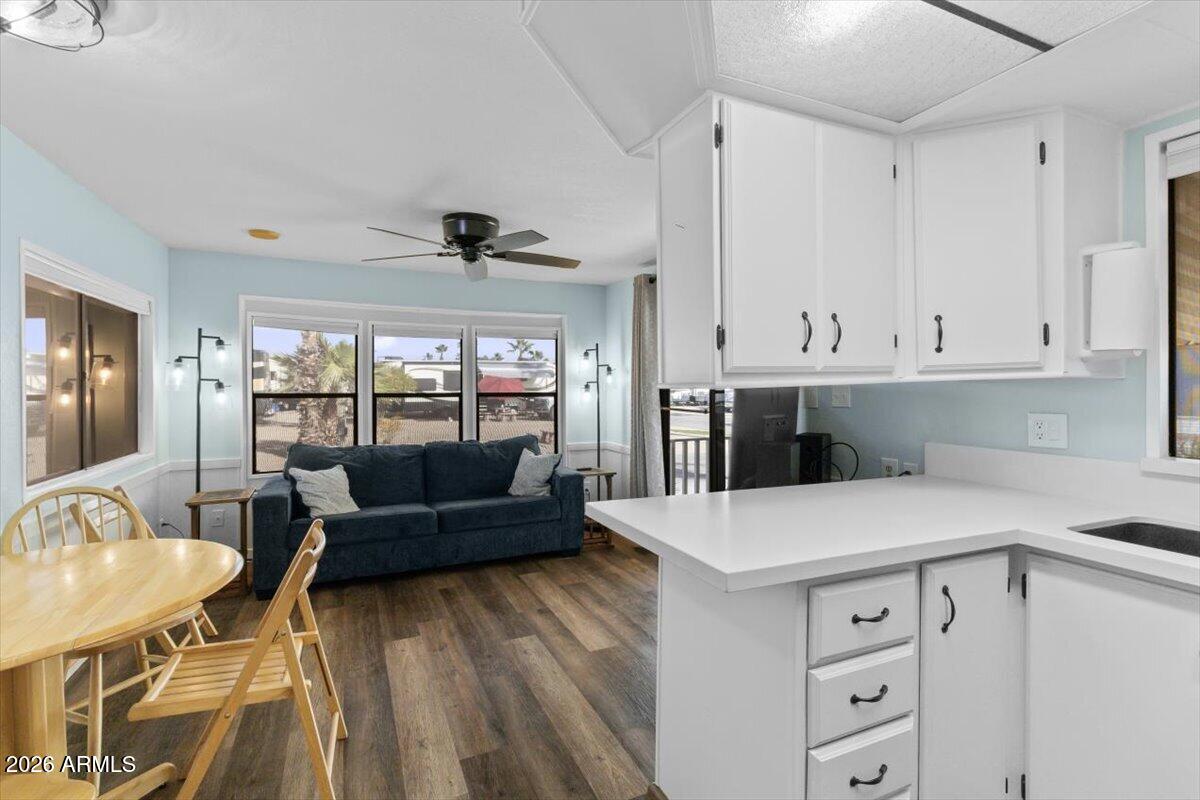 11201 North El Mirage Road, Unit 725 El Mirage, AZ 85335 - Photo 3 of 15 a living room with kitchen island furniture and a fireplace