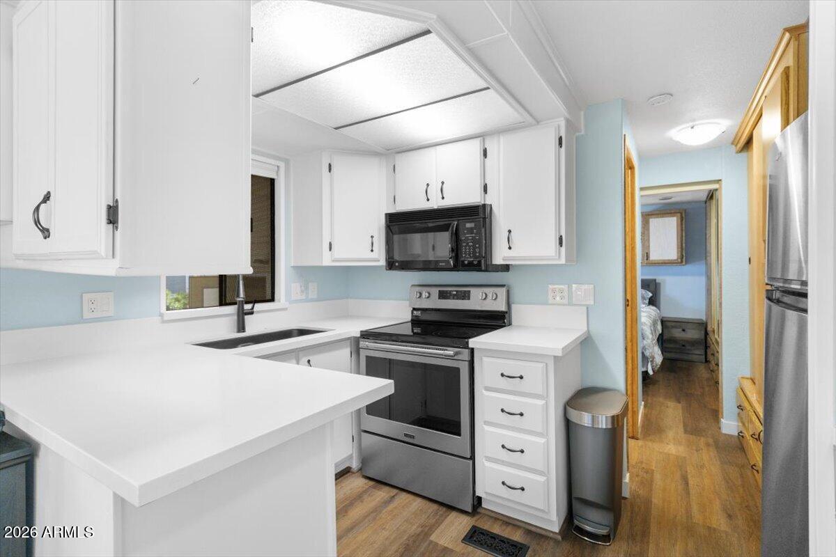 11201 North El Mirage Road, Unit 725 El Mirage, AZ 85335 - Photo 6 of 15 a kitchen with a stove a sink and a refrigerator
