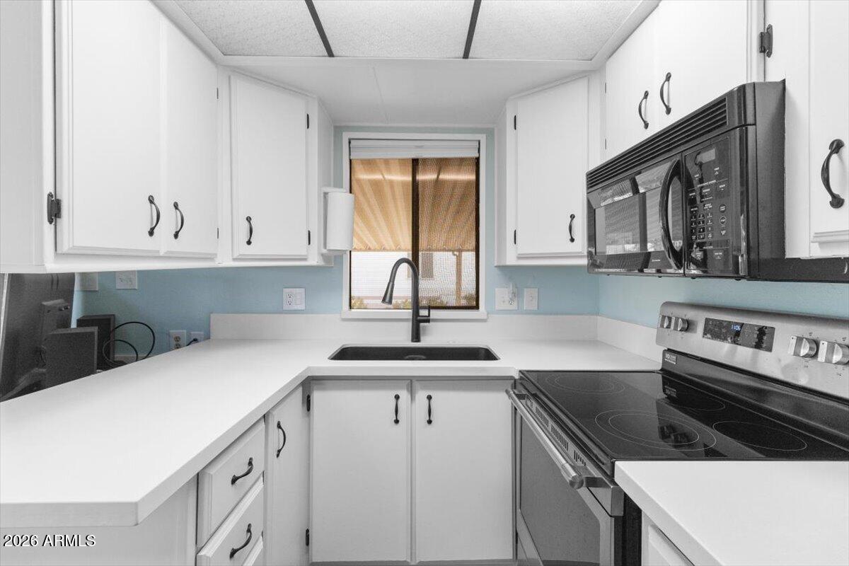 11201 North El Mirage Road, Unit 725 El Mirage, AZ 85335 - Photo 7 of 15 a kitchen with cabinets appliances a sink and a window