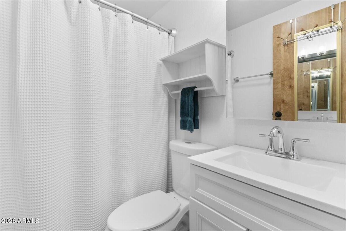 11201 North El Mirage Road, Unit 725 El Mirage, AZ 85335 - Photo 8 of 15 a bathroom with a sink a toilet and shower curtain