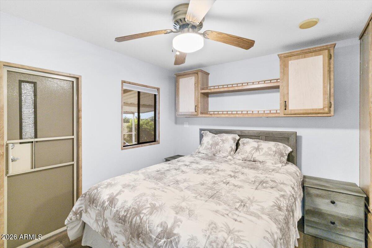 11201 North El Mirage Road, Unit 725 El Mirage, AZ 85335 - Photo 9 of 15 a bedroom with a bed and a chandelier