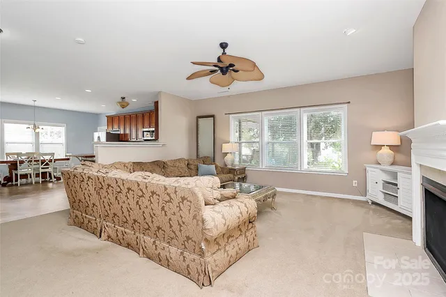 a living room with furniture kitchen view and a chandelier