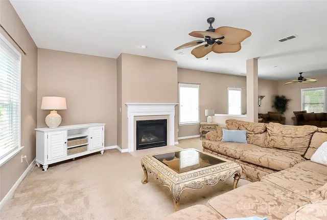 a kitchen with kitchen island granite countertop wooden cabinets a stove a sink a dining table and chairs