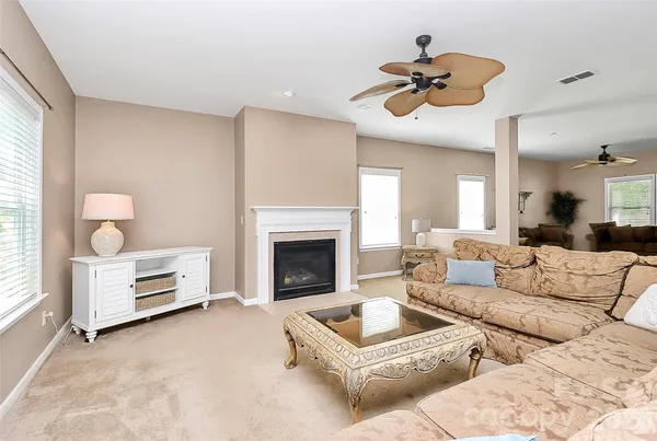 a kitchen with kitchen island granite countertop wooden cabinets a stove a sink a dining table and chairs