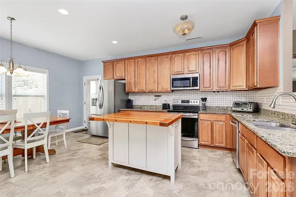 a kitchen with a stove a table and chairs in it