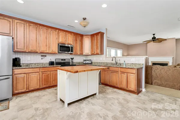 a dining room with furniture a chandelier and kitchen view