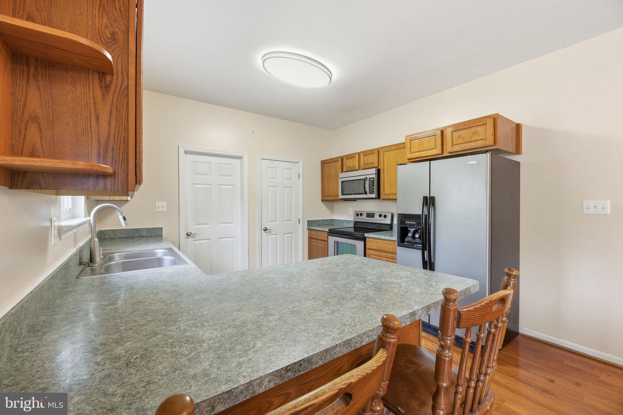 405 Ball Road St. Leonard, MD 20685 - Photo 17 of 40 a kitchen with stainless steel appliances granite countertop a sink refrigerator and microwave