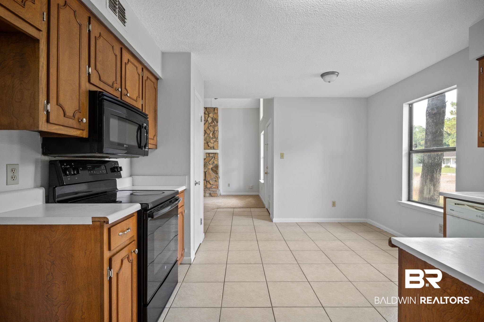 3701 Vista Ridge Drive Mobile, AL 36693 - Photo 10 of 33 Kitchen featuring light tile patterned floors, a textured ceiling, and black appliances