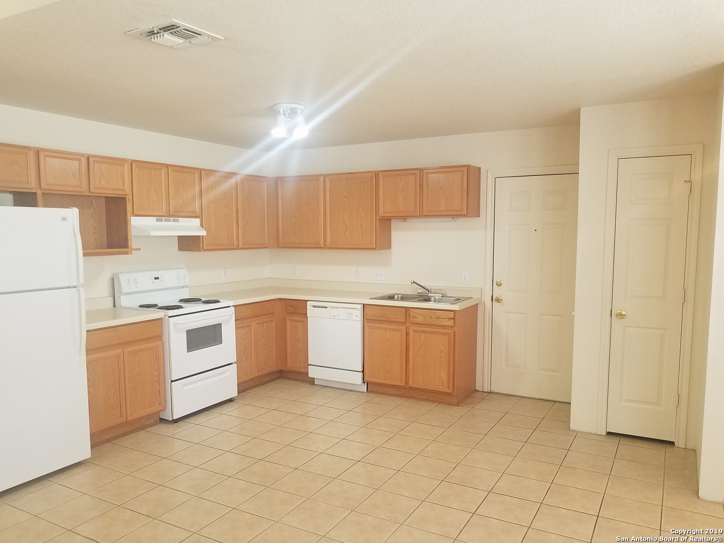 11207 Terra Loop Road San Antonio, TX 78233 - Photo 2 of 7 a kitchen with a white stove refrigerator and cabinets