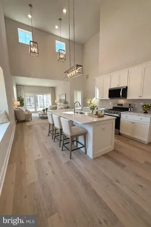 a large kitchen with a counter top space a sink stainless steel appliances and cabinets