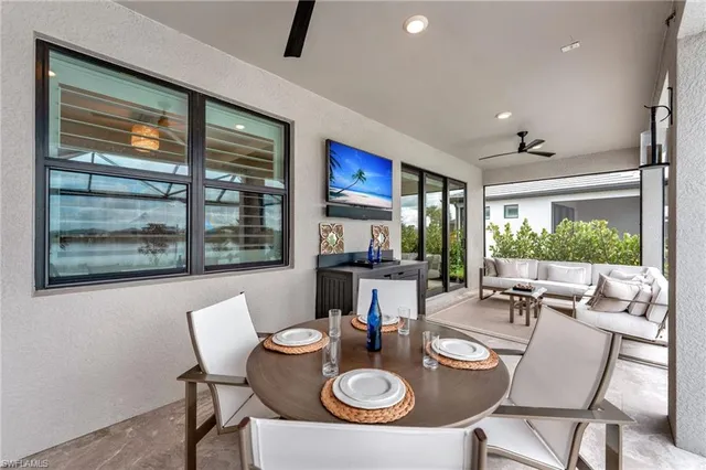 a dining room with furniture a rug and a floor to ceiling window