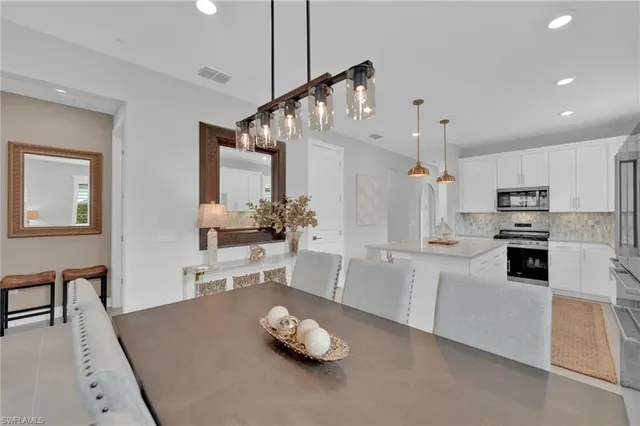 a large white kitchen with cabinets