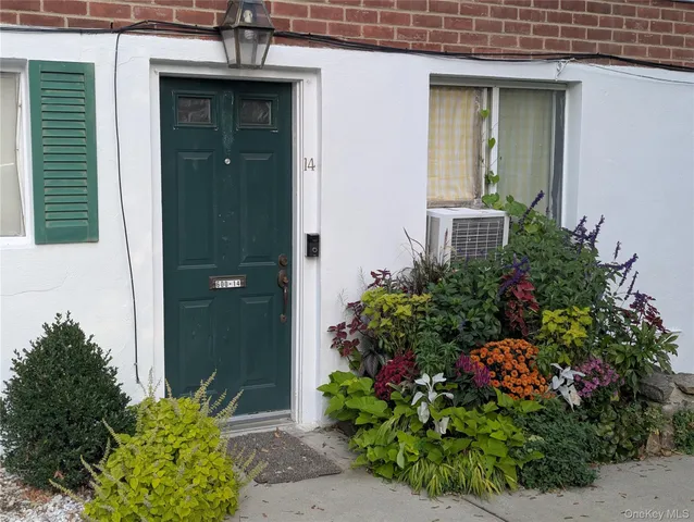 a view of a house with a yard and potted plants