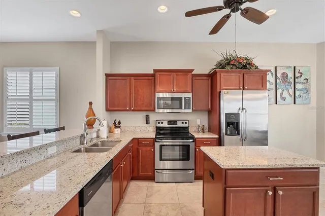 a kitchen with stainless steel appliances granite countertop a sink a stove and a refrigerator