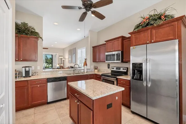 a kitchen with stainless steel appliances granite countertop a sink a stove a refrigerator a washer dryer and white cabinets