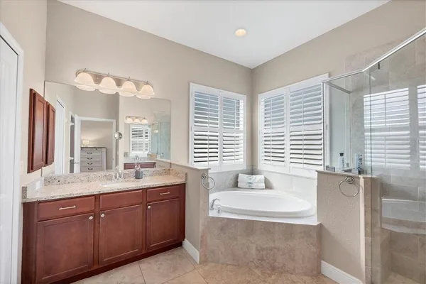 a spacious bathroom with a granite countertop tub sink and mirror