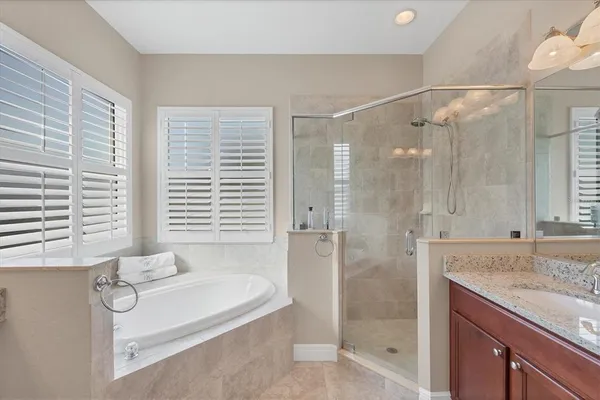 a bathroom with a granite countertop bathtub shower and sink