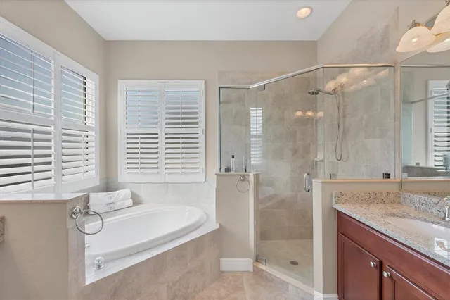 a bathroom with a granite countertop bathtub shower and sink