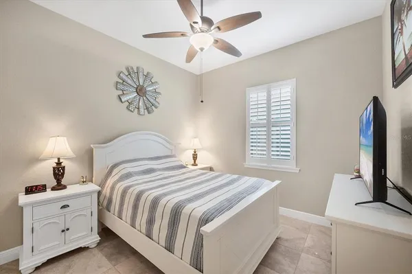a bedroom with bed tv and a chandelier