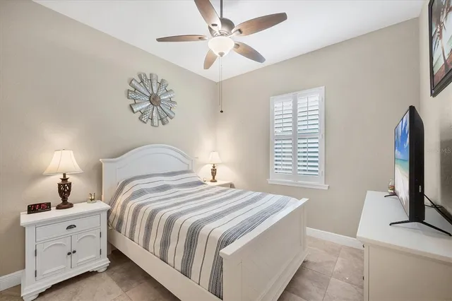 a bedroom with bed tv and a chandelier