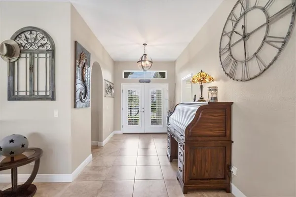 a living room with furniture a chandelier and a window
