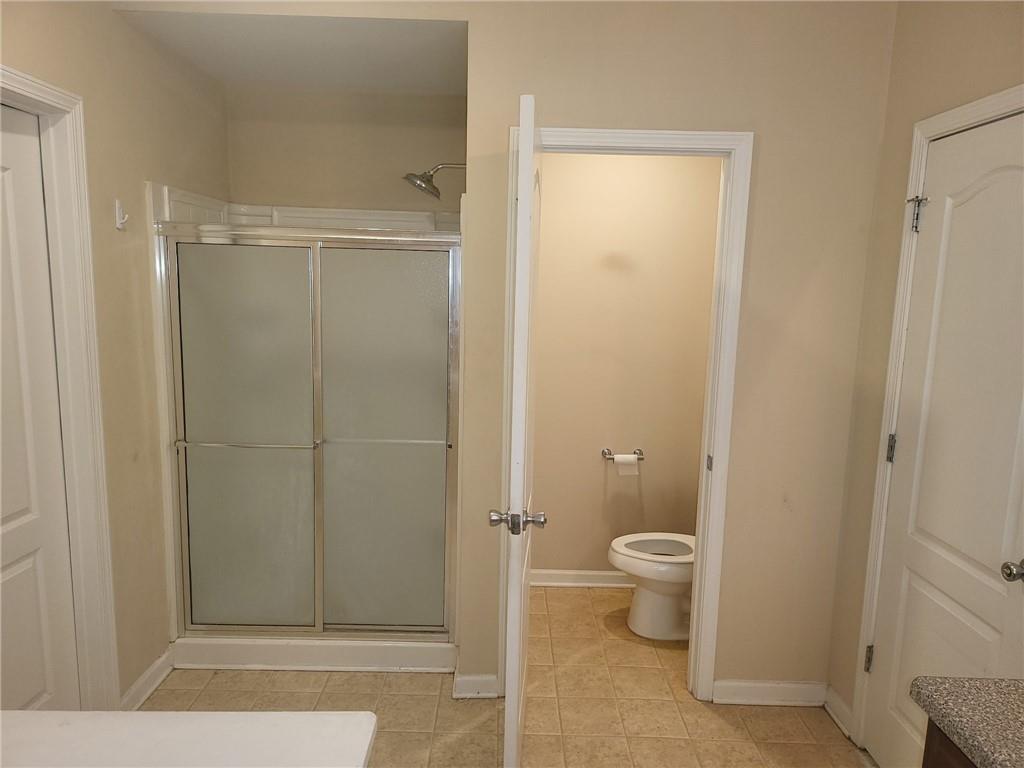 91 Meeting Pl Road Lawrenceville, GA 30044 - Photo 14 of 18 a bathroom with a granite countertop toilet and a shower