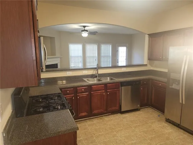 a kitchen with stainless steel appliances granite countertop a sink stove and refrigerator