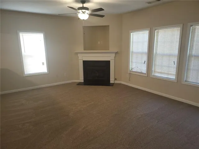 an empty room with windows and fireplace