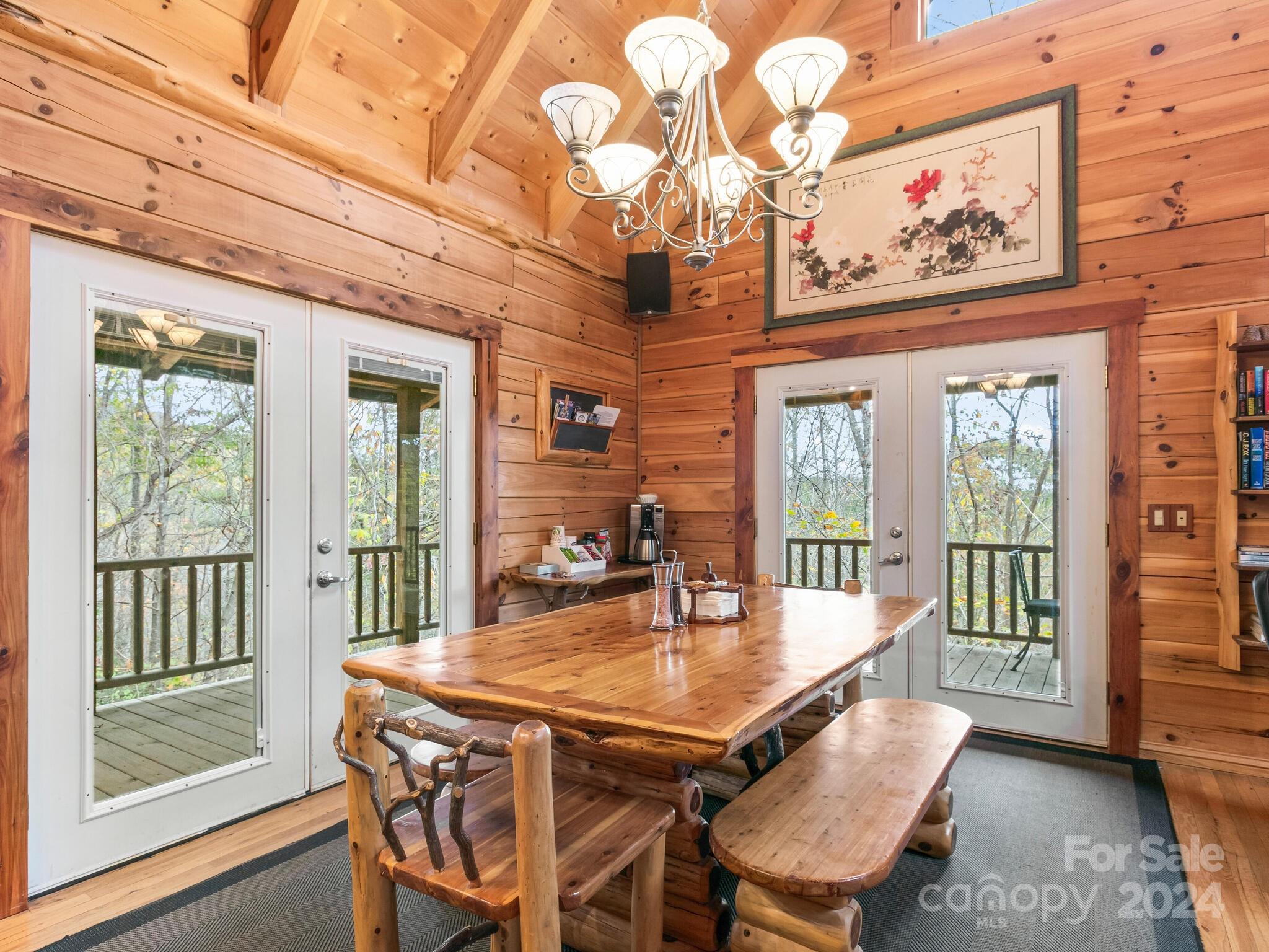 354 Nelons Road Mill Spring, NC 28756 - Photo 14 of 32 a dining room with wooden floor furniture and a chandelier