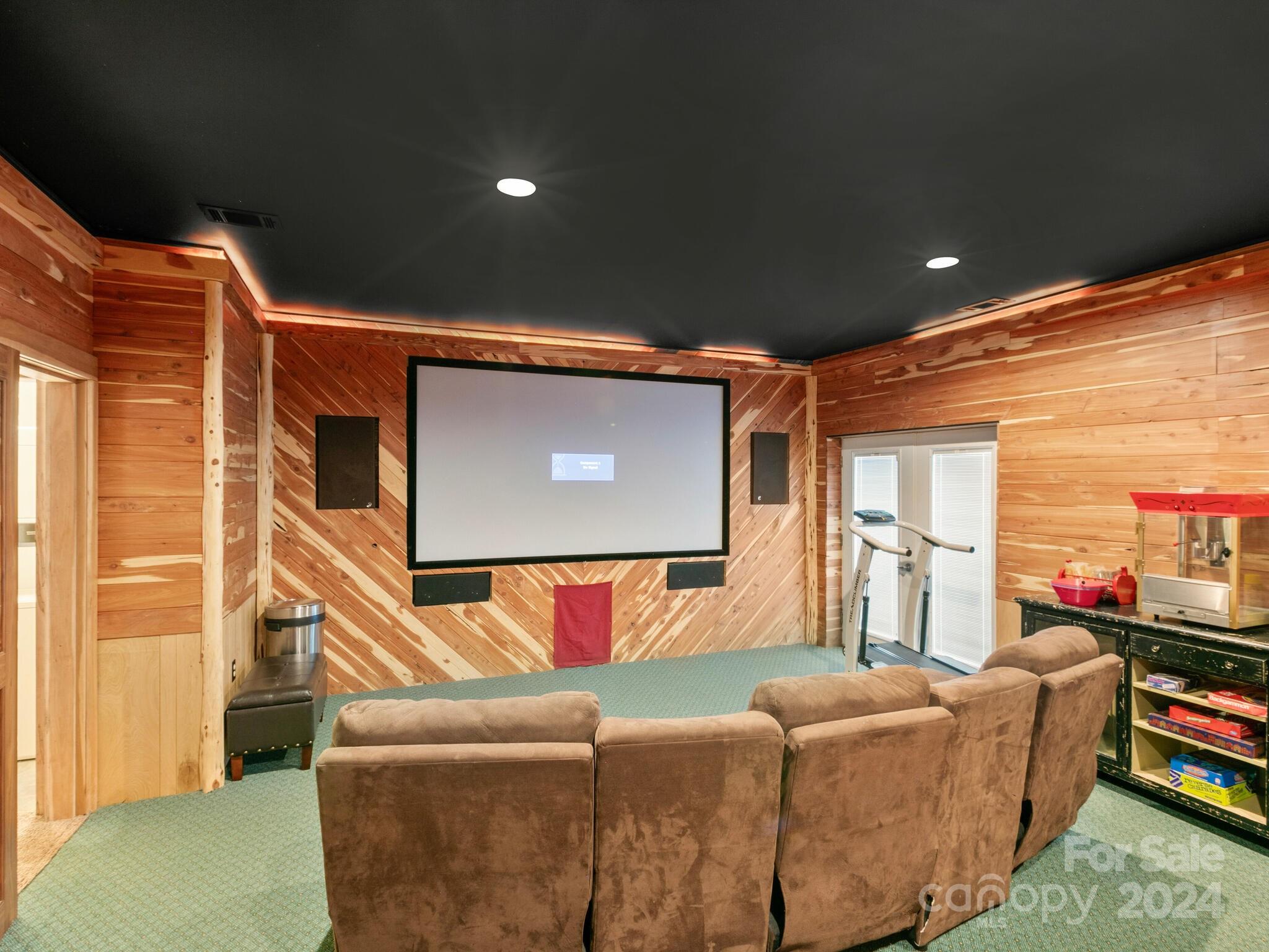 354 Nelons Road Mill Spring, NC 28756 - Photo 26 of 32 a living room with furniture a flat screen tv and a floor to ceiling window