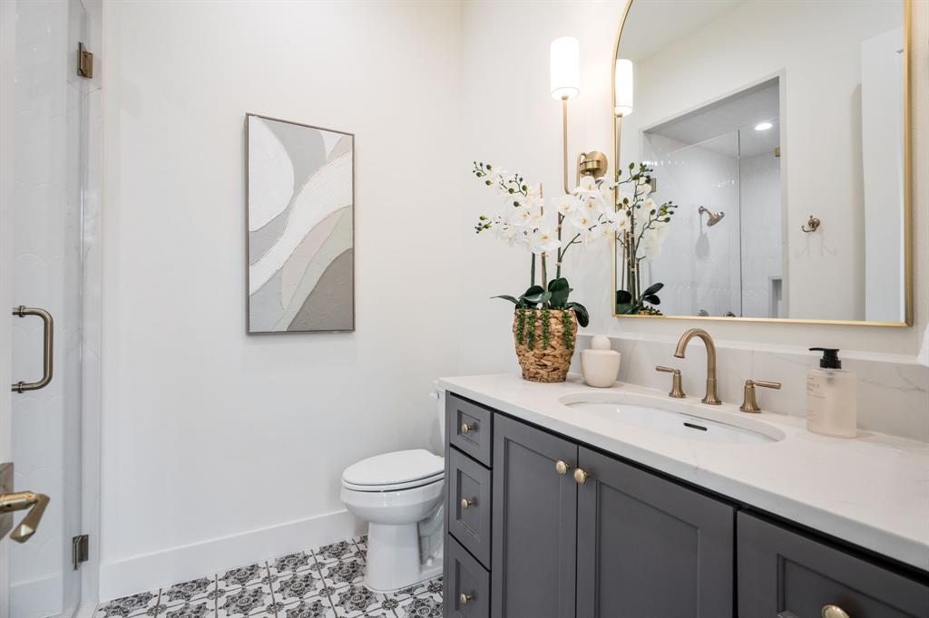3304 Ferguson Road Grapevine, TX 76092 - Photo 7 of 38 Bathroom featuring a gray vanity with gold-toned hardware, a white undermount sink, and a white countertop